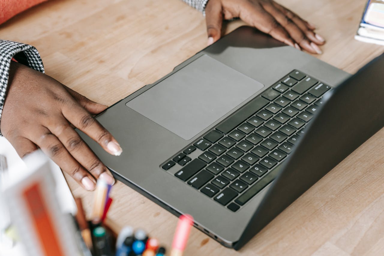Close-up of woman's hands on laptop keyboard in a professional office environment, perfect for business or tech themes.