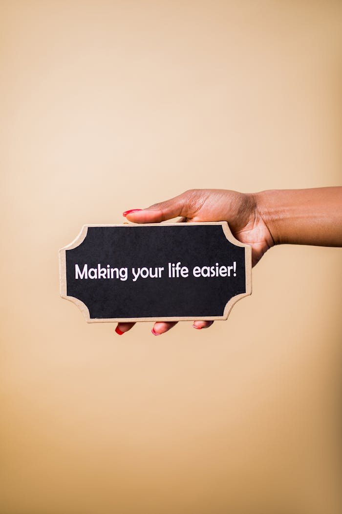 Close-up of a hand holding a sign that reads'Making your life easier.' Perfect for motivational content.